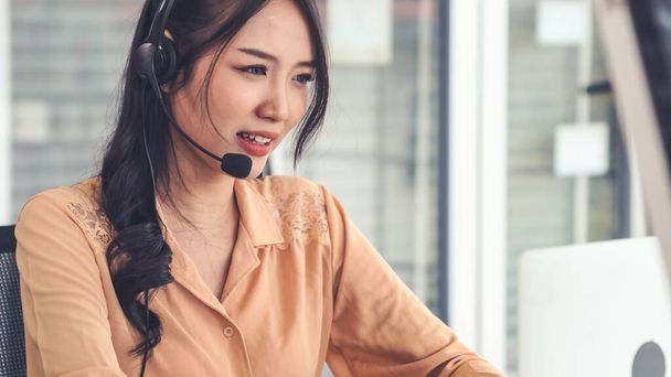 Businesswoman wearing headset working actively in office - Photo, Image