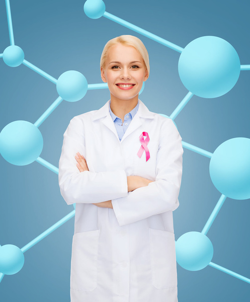 smiling female doctor with cancer awareness ribbon - Фото, зображення