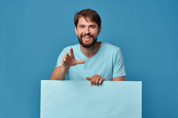 Cheerful man blue paper in the hands of marketing fun Lifestyle isolated background - Photo, Image