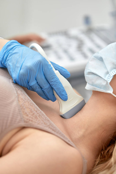 Mulher recebendo ultra-som de uma tireóide do médico
 - Foto, Imagem