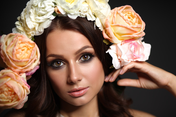 Portrait of a beautiful woman with flowers in her hair. Fashion photo - 写真・画像