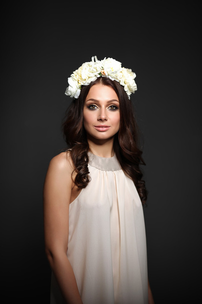 Portrait of a beautiful woman with flowers in her hair. Fashion photo - Фото, изображение