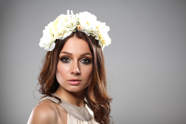 Portrait of a beautiful woman with flowers in her hair. Fashion photo - Zdjęcie, obraz