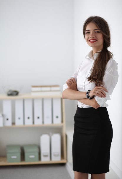 Attractive businesswoman with her arms crossed  standing in office - Photo, image