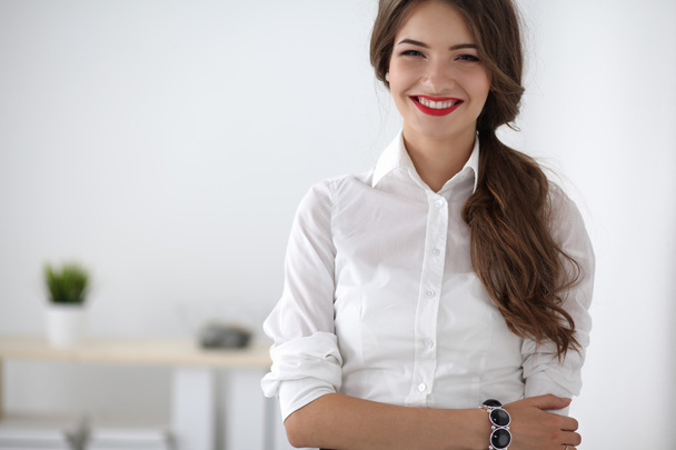 Attractive businesswoman with her arms crossed  standing in office - Foto, imagen