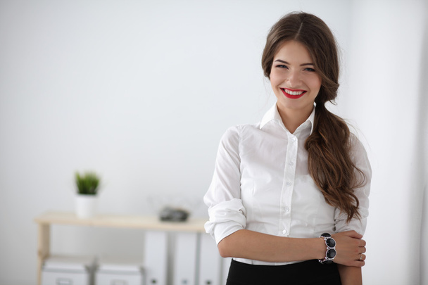 Attractive businesswoman with her arms crossed  standing in office - Zdjęcie, obraz