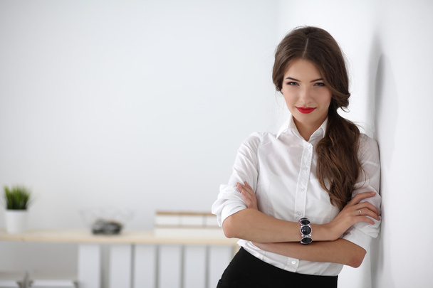 Attractive businesswoman with her arms crossed  standing in office - Foto, Imagen