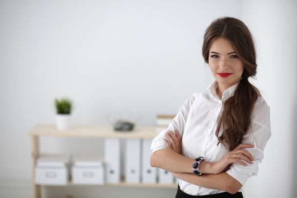 Attractive businesswoman with her arms crossed  standing in office - Foto, immagini
