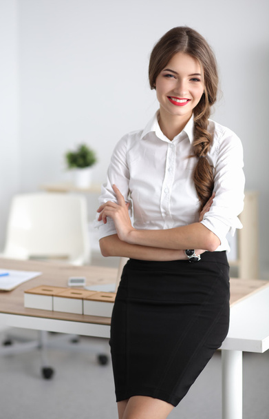 Attractive businesswoman with her arms crossed  standing in office - Foto, Imagen