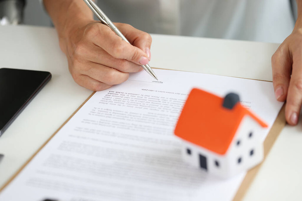 Žena podepíše smlouvu o koupi domu v kanceláři detailní záběr - Fotografie, Obrázek