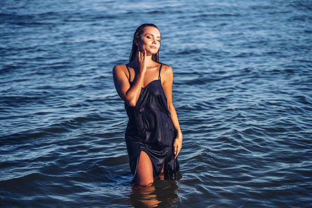 Beautiful girl in dress posing in water. tropic island girl, beautiful tan, skin care, pretty face - Foto, Imagem