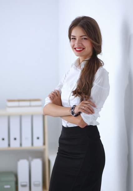 Attractive businesswoman with her arms crossed  standing in off - Fotó, kép