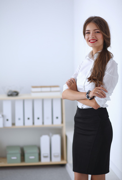 Attractive businesswoman with her arms crossed  standing in off - Photo, Image
