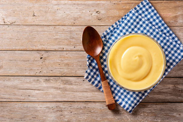 Crème pâtissière dans un bol sur une table en bois. Vue de dessus. Espace de copie - Photo, image