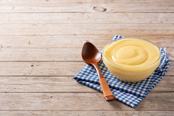 Crème pâtissière dans un bol sur une table en bois. Espace de copie - Photo, image
