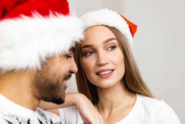 Cheerful attractive happy couple in Santa hats - Fotoğraf, Görsel