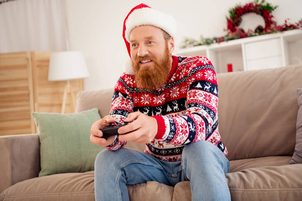 Photo of smiling guy sit sofa couch having fun free time relaxing at home celebrate winter vacation new year play playstation - Fotografie, Obrázek