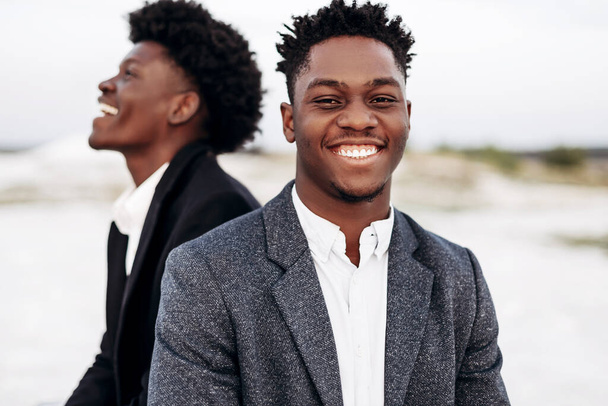 Two trendy African black men, outdoors, in stylish classic clothes, with fashionable hairstyle, Handsome men, model portrait, Fashion concept, mens clothing - Foto, immagini