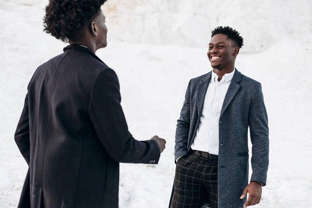 Two happy black fashionable men posing in the street, friends in classic black suits, fashion posing in nature, Menswear concept, shopping, - Foto, Imagen