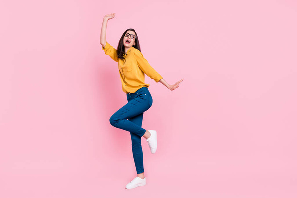 Full length photo of cool brunette hairdo young lady dance wear shirt eyewear trousers sneakers isolated on pink background - 写真・画像