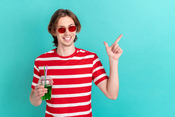 Photo of young guy happy smile drink cocktails travel point finger empty space ad choice isolated over teal color background - Fotografie, Obrázek
