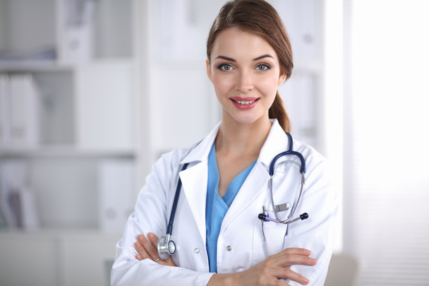 Portrait of young woman doctor with white coat standing in hospital - Photo, Image