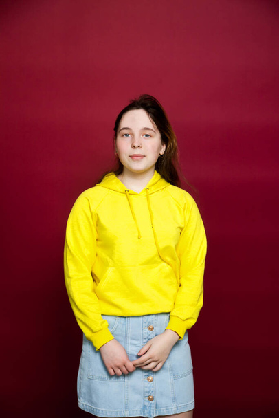 Portrait of   beautiful teenage girl on red background - Photo, Image