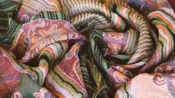 Elegante kleurrijke sjaal, stof, sjaal, oranje, gouden, groene, gemengde kleur. Abstracte stof achtergrond patroon. - Video