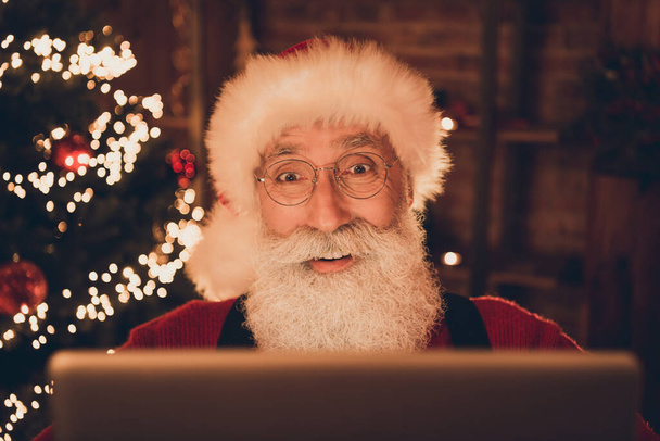 Photo of senior santa claus happy positive smile look read browse monitor computer virtual decor lights christmas indoors - 写真・画像