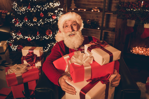 Photo of senior santa claus happy positive smile sit armchair hold present box new year atmosphere lights miracle indoors - Fotografie, Obrázek
