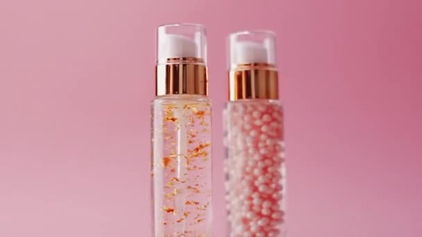 Prodotti di bellezza per la cura della pelle su sfondo rosa, trucco e cosmetici  - Filmati, video