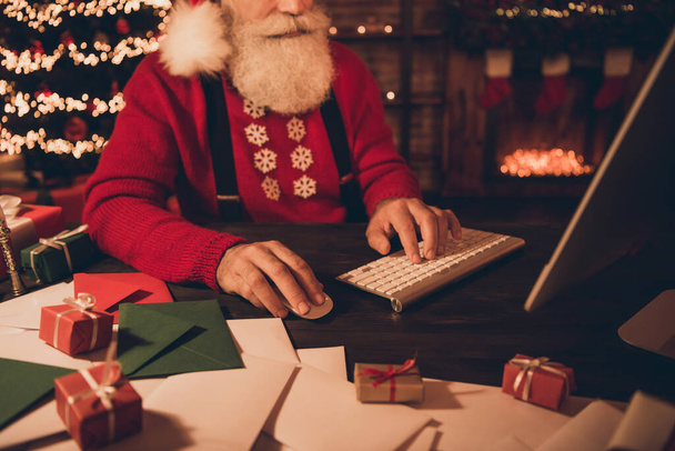 Cropped photo portrait santa claus typing message using keyboard sitting at table in winter - Zdjęcie, obraz