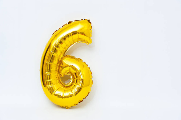 Inflatable numeral 6 sparkling metallic golden color isolated on white background. Close-up. Copy space. - Fotografie, Obrázek