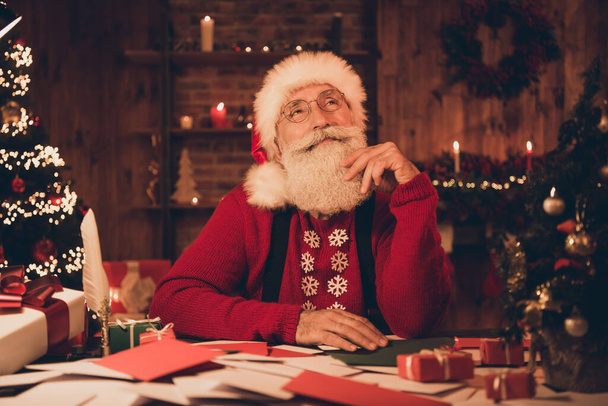 Photo of aged santa claus happy positive smile hand touch beard think dream enjoy eve time noel decoration atmosphere indoors - Foto, immagini