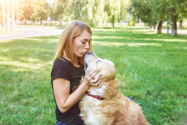 молода жінка зі своїм собакою ретривер на відкритому повітрі
. - Фото, зображення