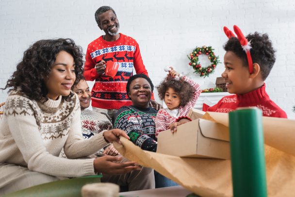 mère et fils emballage boîte cadeau près heureuse famille afro-américaine - Photo, image