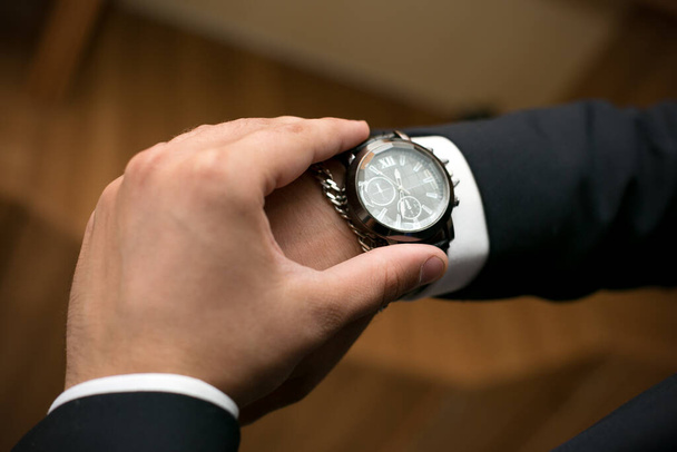 A man looks at his wristwatch afraid of being late for a date. - Photo, Image