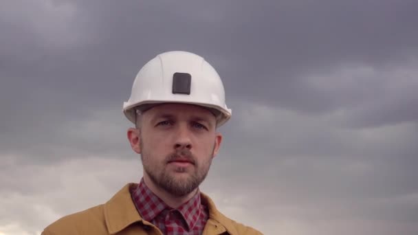 Stavební dodavatel na staveništi opravuje bílou přilbu - Záběry, video