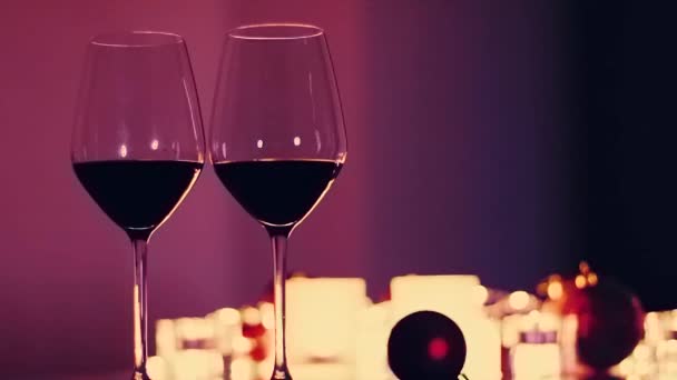 Romántica fecha noche fondo, copas de vino tinto y velas doradas - Metraje, vídeo