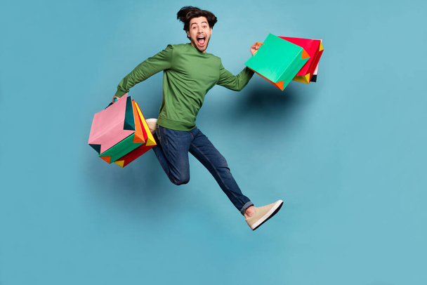 Full size photo of funky screaming young man good mood running after shopping isolated on blue color background - Photo, Image