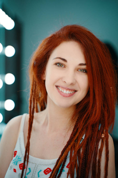 Smiling red-haired girl with long dreadlocks. - Фото, зображення