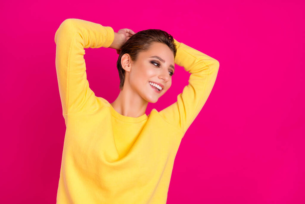 Photo of charming pretty young lady wear yellow jumper smiling arms behind head looking empty space isolated pink color background - Φωτογραφία, εικόνα