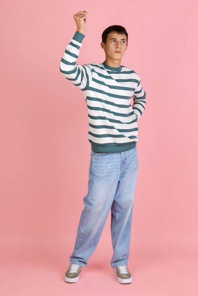 Portrait of young man, student or boy in casual clothes isolated on pink studio backgroud. Human emotions concept. - Фото, изображение