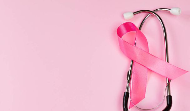 Měsíc povědomí o rakovině prsu. Růžová stuha a stetoskop na barevném pozadí. Dámská koncepce zdravotní péče. Symbol boje proti onkologii. Kopírovat prostor. - Fotografie, Obrázek