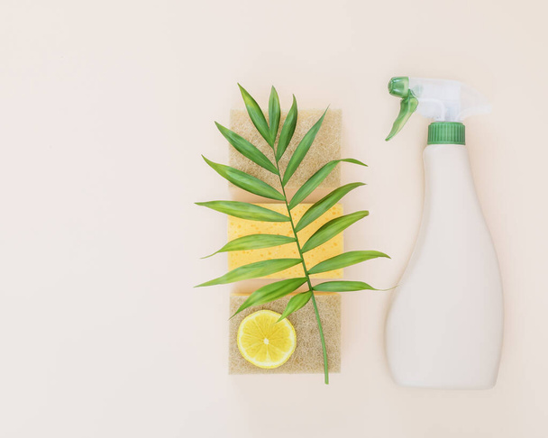 Eco friendly home cleaning composition with a bottle of natural detergent for windows and glass surfaces, sponges for washing, lemon and copy space. Mockup for eco friendly natural cleaning products - Fotó, kép