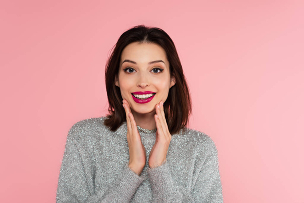 Pretty brunette woman in sweater looking at camera isolated on pink  - Foto, Imagen