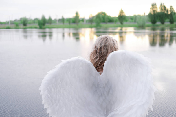 Γυναίκα με φτερά λευκού αγγέλου. Όμορφη ξανθιά με αγγελική στολή. Παράδεισος, αγνότητα. καλός άνθρωπος - Φωτογραφία, εικόνα