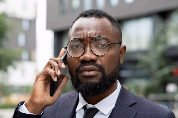 Face of young elegant businessman in eyeglasses speaking on the phone - Photo, image
