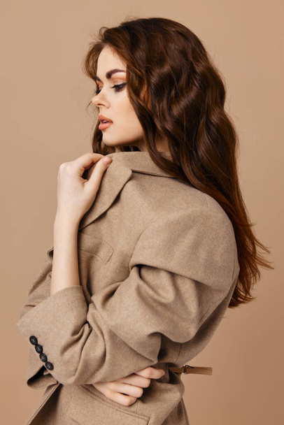 beautiful brunette  side view beige background. High quality photo - 写真・画像