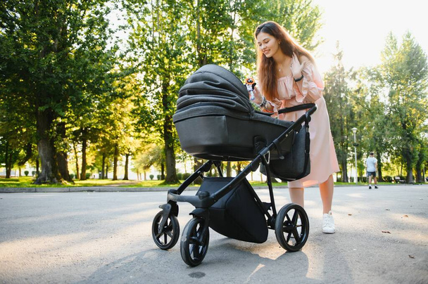 Mother with baby carriage in the park - Foto, Imagen